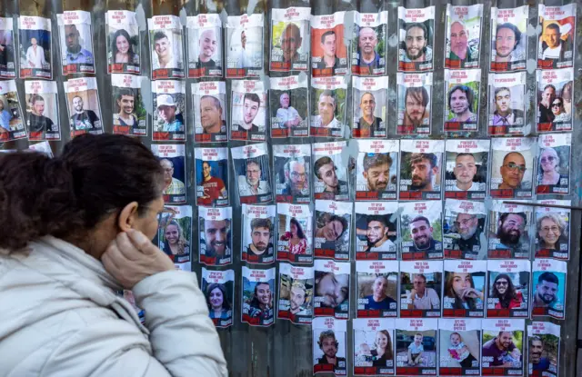 A woman looks at pictures of Israelis captured by Hamas fighters