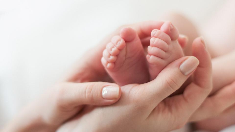 the baby's feet in the mother's arms